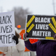 Demonstrators hold “Black Lives Matter” signs in front of the US District Court in St Paul, Minnesota, on February 24, 2022.